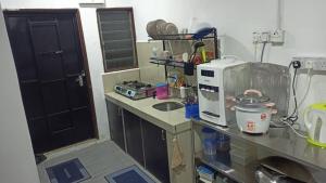 a kitchen with a counter top with a microwave at TokBi Homestay Gerik in Gerik +4 photos