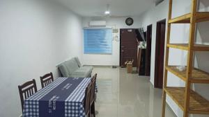 a room with a table and a couch in a room at TokBi Homestay Gerik in Gerik