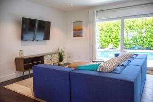 a blue couch in a living room with a tv at Villa Palma-Hollywood Beach - Winter & Spring Break Getaway! in Hollywood