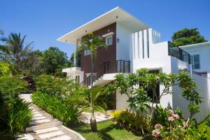 a white house with plants in front of it at One Hagdan Villas in Boracay