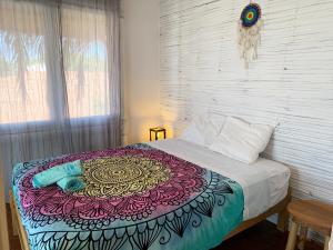a bed with a colorful blanket on it in a bedroom at Palo Santo Sanctuary in Canoas De Punta Sal