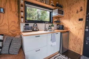 a kitchen in a tiny home with a sink and a window at Tiny House at the Moorings in Dunalley