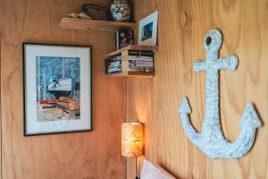 a wall with a picture and a anchor on it at Tiny House at the Moorings in Dunalley
