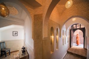 a hallway with arched ceilings and a woman in a dress in the distance at Riad Star by Marrakech Riad in Marrakech