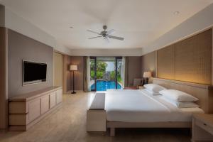 a bedroom with a large bed and a television at Conrad Bali in Nusa Dua