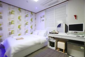 a bedroom with a bed and a desk with a computer at Itaewon A One Hotel in Seoul