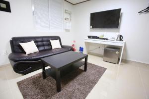 - un salon avec un canapé en cuir noir et une table dans l'établissement Itaewon A One Hotel, à Séoul
