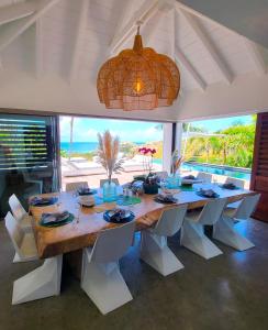 een eetkamer met een tafel en uitzicht op de oceaan bij Villa Coco Rock in Saint Barthelemy