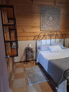 1 dormitorio con 1 cama y pared de madera en Preciosa cabaña en Fraijanes, en Fraijanes