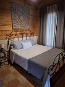 1 dormitorio con 1 cama en una habitación con ventana en Preciosa cabaña en Fraijanes, en Fraijanes