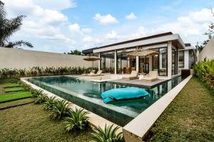 an infinity pool in a villa with chairs and a house at Villa Elma by BaliSuperHost in Ubud +33 photos