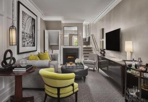 a living room with a couch and chairs and a tv at Rosewood Washington DC in Washington