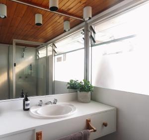 a bathroom with a sink and a mirror at Pippi Beach Loft in Yamba
