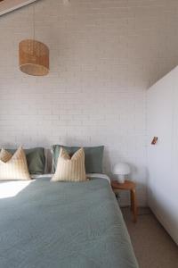 a bedroom with a bed with two pillows on it at Pippi Beach Loft in Yamba