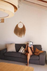 a man laying on a couch reading a book at Pippi Beach Loft in Yamba