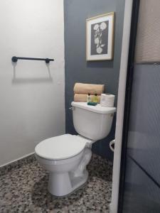 a bathroom with a white toilet in a room at Ramona loft in Villahermosa