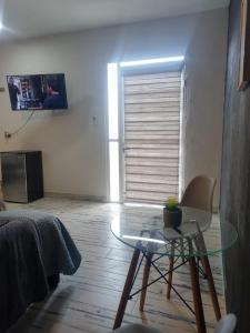 a living room with a glass table and a door at Ramona loft in Villahermosa