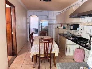 a kitchen with a table and chairs and a kitchen with a stove at Pousada Lopes na Fama in Goiânia