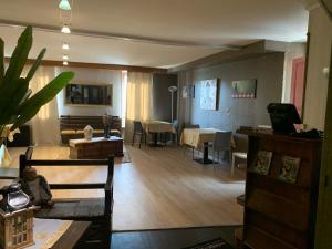 a living room with a table and chairs and a dining room at Hotel Colombié in Gorses