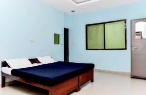 博帕爾的住宿－OYO Hotel Avani Palace，蓝色墙壁间的一张床位