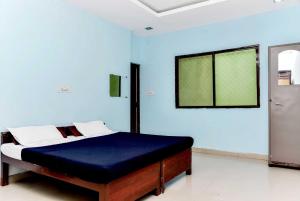 博帕爾的住宿－OYO Hotel Avani Palace，一间卧室配有一张蓝色墙壁的床和一扇窗户