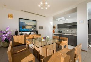 a dining room with a glass table and wooden chairs at The heights Penthouse Ocean view A11 in Kata Beach