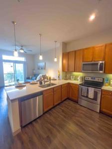 a kitchen with wooden cabinets and stainless steel appliances at Downtown Houston Gem: Parking Pool WiFi Sleeps 4 in Houston
