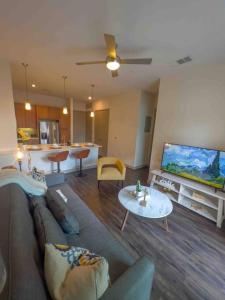a living room with a couch and a flat screen tv at Downtown Houston Gem: Parking Pool WiFi Sleeps 4 in Houston