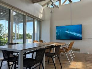 a dining room with a table and chairs and a tv at 727セブンツーセブン石垣島ベース in Ishigaki Island
