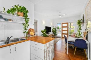 Una cocina con fregadero y una mesa con sillas. en Beach Pad close to Airport and Iconic Kirra Beach, en Gold Coast