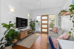Una sala de estar con un sofá y un televisor. en Beach Pad close to Airport and Iconic Kirra Beach, en Gold Coast
