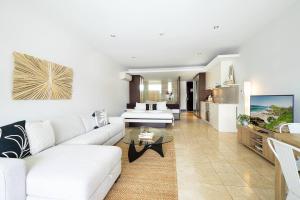 un soggiorno con un divano bianco e un tavolo di Luxury Resort Studio with Pool - Footsteps to Beach a Casuarina