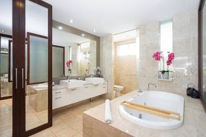 un ampio bagno con due lavandini e una vasca di Luxury Resort Studio with Pool - Footsteps to Beach a Casuarina