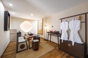 a room with a kitchen with a table and a refrigerator at Honglu Garden Hotel Xi'an Bell and Drum Tower Huimin Street Store in Xi'an