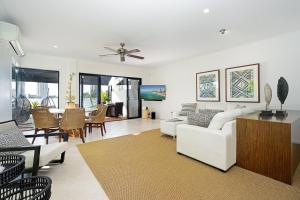 ein Wohnzimmer mit weißen Möbeln und ein Esszimmer in der Unterkunft Chevron Escape - An Exquisite Waterfront Townhouse in Gold Coast