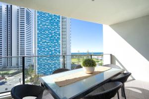 uma mesa e cadeiras numa varanda com vista para os edifícios em Luxe High-rise with Al Fresco Dining & Ocean views em Gold Coast