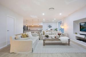 ein Wohnzimmer mit einem weißen Sofa und einem Tisch in der Unterkunft Contemporary Coastal Luxury with an Outdoor Pool in Gold Coast