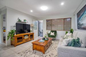 a living room with a couch and a tv at 'Buzzing Surfers' Vibrant Indoor-outdoor Lifestyle in Gold Coast