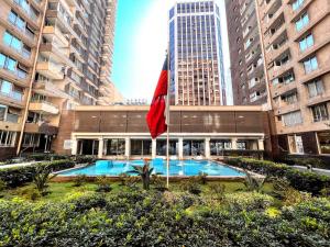 um edifício com piscina e bandeira vermelha em HABITACION CON BAÑO PRIVADO, Depto HOME ESTUDIOS Gran Santiago Apartments em Santiago