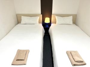 two twin beds sitting next to each other in a room at Hotel Links Dobutsuenmae in Osaka