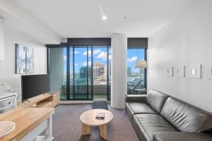 a living room with a couch and a table at Resort Style Living Yarra Wharf in Melbourne
