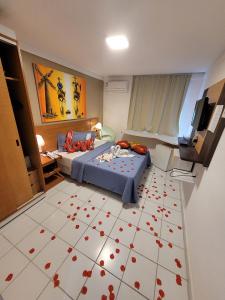 1 dormitorio con 1 cama con corazones rojos en el suelo en Apart-Hotel Beira Mar de Ponta Negra - Harmony Suítes, en Natal