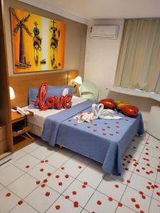 un dormitorio con una cama con las palabras de amor en ella en Apart-Hotel Beira Mar de Ponta Negra - Harmony Suítes, en Natal