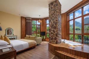 a bedroom with a bed and a stone fireplace at Yangshuo Coco Garden Hotel in Yangshuo