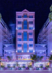 ein hohes Gebäude mit einem Schild in der Nacht in der Unterkunft Cap Town Hotel in Ho-Chi-Minh-Stadt