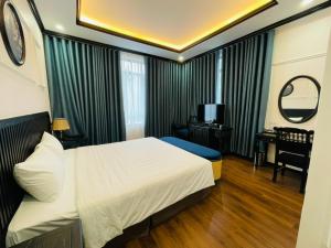 ニンビンにあるMoma Paris Hotel Ninh Bìnhのベッドとデスクが備わるホテルルームです。