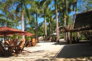 a group of tables and umbrellas on a beach at Estrella de Mar Home in Jobos