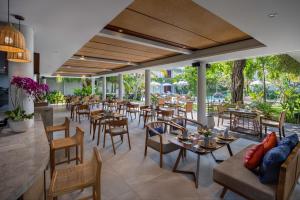 a dining room with tables and chairs and a restaurant at The Hava Ubud A Pramana Experience in Ubud