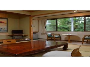 Kami - Hotel / Vacation STAY 15957 في Kami: غرفة معيشة مع طاولة وكراسي خشبية
