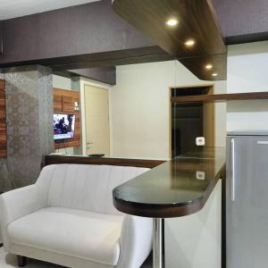 a kitchen with a white couch and a table and a refrigerator at Apartemen Educity Pakuwon city Surabaya BACA DESKRIPSI DULU in Surabaya